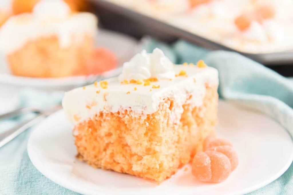 orange creamsicle poke cake on white plate