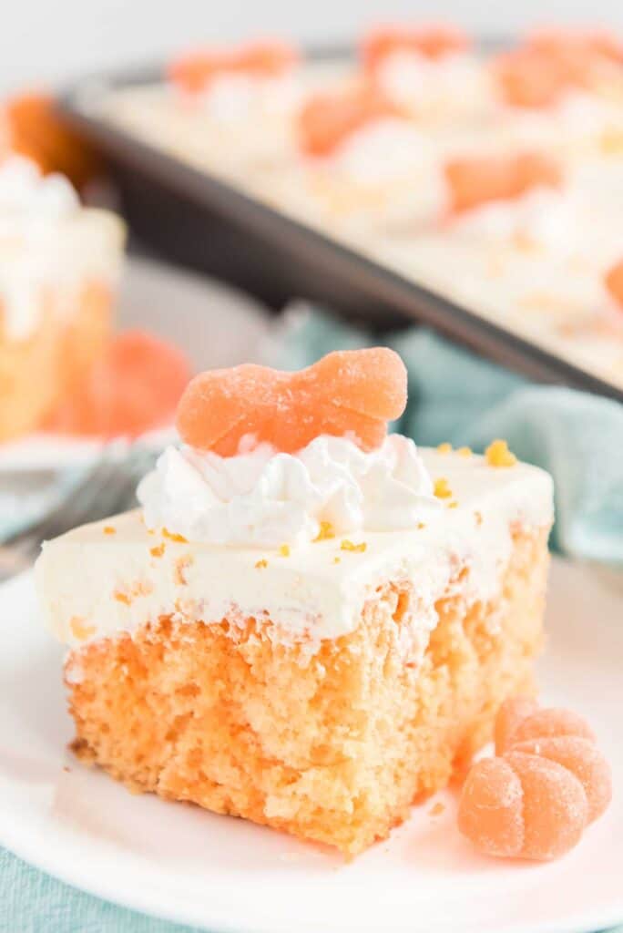 orange creamsicle poke cake on white plate