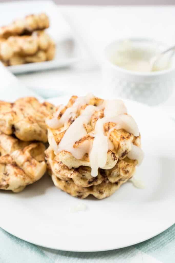 cinnamon bun waffles drizzled with cream cheese frosting