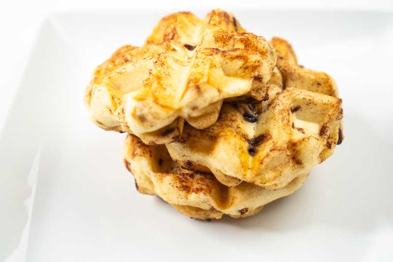 cinnamon buns cooked in waffle maker on white plat