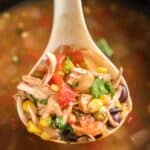 close up of tortilla soup in ladle