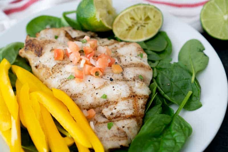 grilled grouper with sliced yellow bell peppers, spinach, and limes