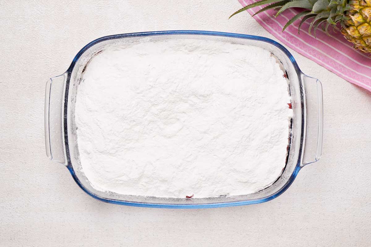 baking dish with cherry pineapple dump cake topped with cake mix