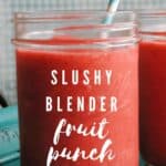 red slushy punch in a mason jar with straw and text reading slushy blender fruit punch