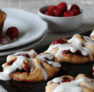 Pull apart raspberry sweet rolls start with refrigerated biscuits, are then filled with fresh tangy raspberries & drizzled with a sweet cream cheese glaze!
