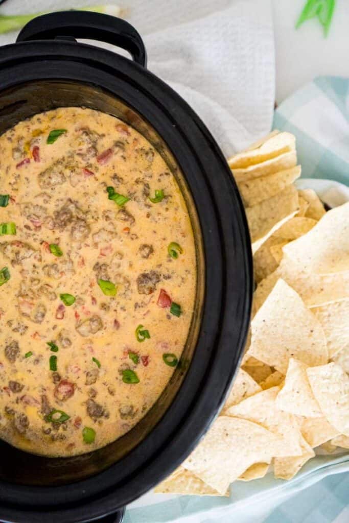 slow cooker with velveeta spicy cheese dip with sausage and ground beef and tortilla chips