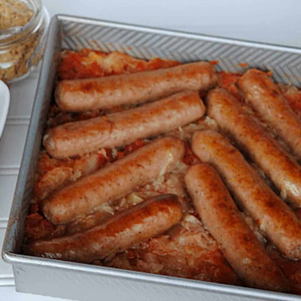 baked kielbasa and sauerkraut in metal baking dish