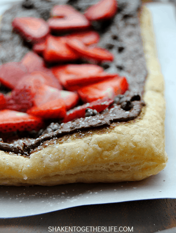 Golden puff pastry gets a warm melty layer of Nutella and chocolate chips, topped with fresh sliced strawberries and then sprinkled with powdered sugar. Oh my gosh, this looks amazing!