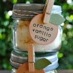 orange vanilla sugar in small jars with labels stacked on one another