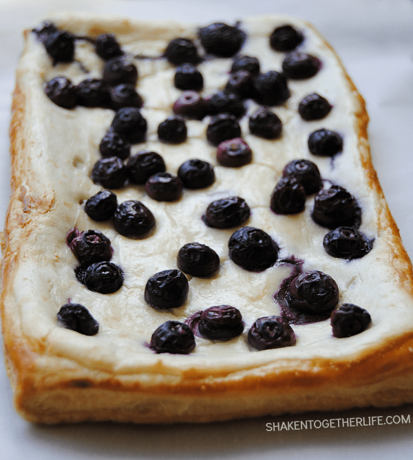 This Blueberry Lemon Cheesecake Tart is SO delicious! Golden flaky puff pastry is topped with a lemon cheesecake filling and fresh blueberries!