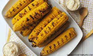 My family raved about Easy Grilled Sweet Corn with homemade garlic Parmesan butter and this one little trick will make this Summer side dish so much easier!