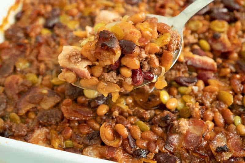 calico beans baked beans in white baking dish and spoon