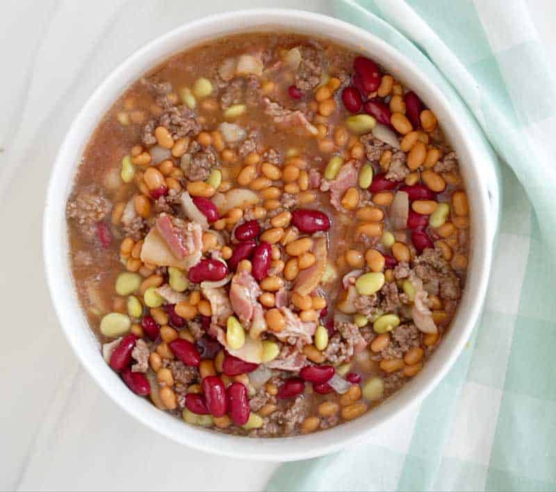 calico beans in white mixing bowl before baking