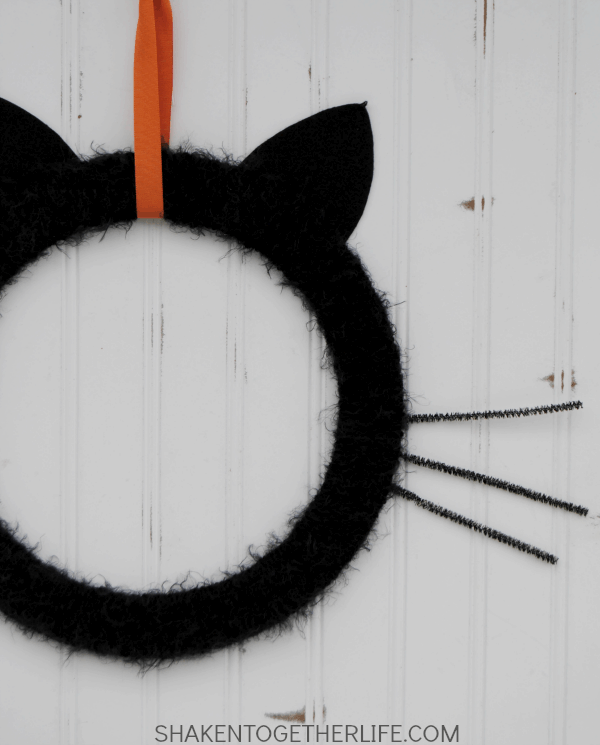 Give your front door or mantel a touch of frightfully furry fun with this easy Black Cat Wreath!