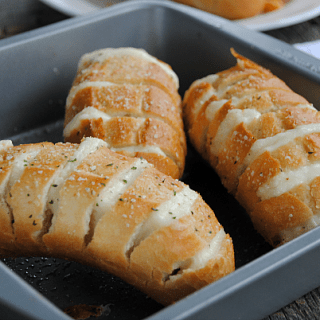 Mozzarella Stuffed Garlic Rolls are a quick and easy side dish! Our family loved to pull apart these ooey gooey cheesy rolls!