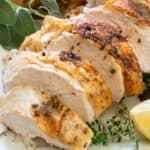 sliced roasted turkey breast on plate with herbs