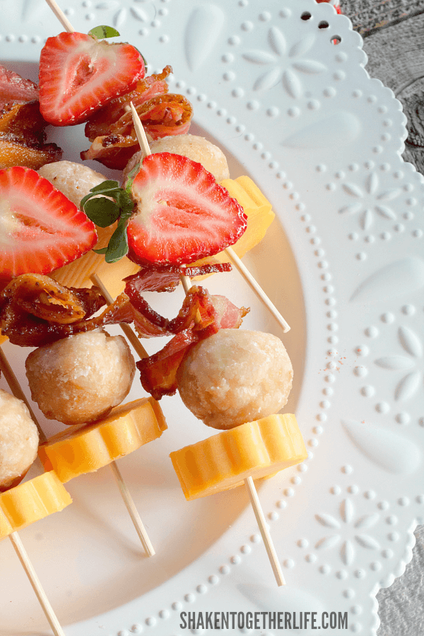 Berry Brunch Kabobs on white plate with strawberry bacon cheese doughnut holes