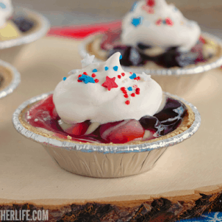 Cherry Berry Patriotic Pudding Pies are the easiest patriotic no bake dessert ever! Tart cherry and sweet blueberry pie filling is swirled through creamy vanilla almond pudding, topped with whipped cream and patriotic sprinkles ... perfect for Memorial Day and July 4th!