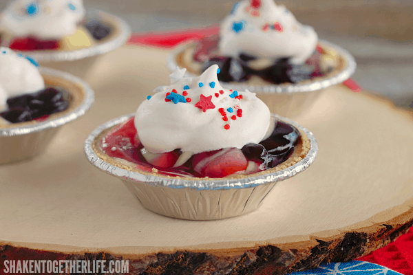 Cherry Berry Patriotic Pudding Pies are the easiest patriotic no bake dessert ever! Tart cherry and sweet blueberry pie filling is swirled through creamy vanilla almond pudding, topped with whipped cream and patriotic sprinkles ... perfect for Memorial Day and July 4th!