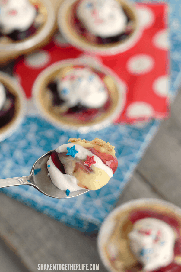 Cherry Berry Patriotic Pudding Pies are the easiest patriotic no bake dessert ever! Tart cherry and sweet blueberry pie filling is swirled through creamy vanilla almond pudding, topped with whipped cream and patriotic sprinkles ... perfect for Memorial Day and July 4th!