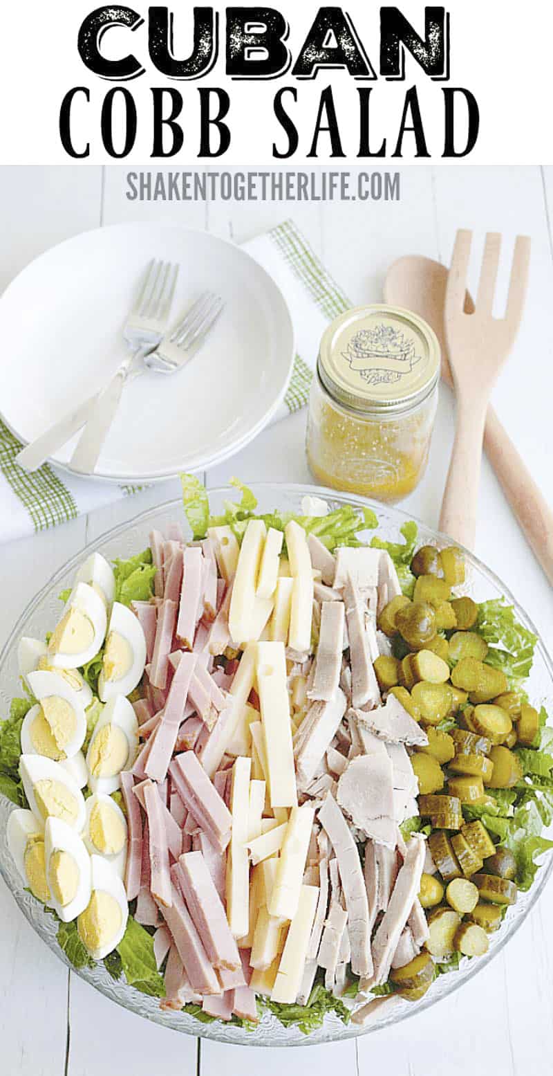 Cuban Cobb Salad on wood table with serving utensils and bowls