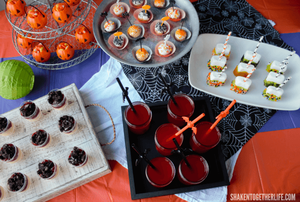 Our Halloween Dessert Bar got layers of color and textures with tablecloths, a gauzy white towel and spider web fabric.