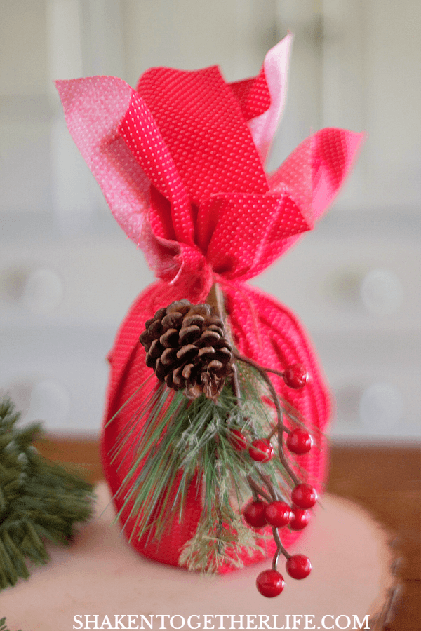 4 Easy Ways to Wrap Candles for Gifts: use a fabric fat quarter and a holiday foliage pick to dress up a medium jar candle!