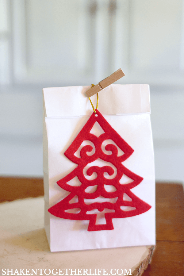 4 Easy Ways to Wrap Candles for Gifts: a simple paper lunch bag, mini clothespin and a felt ornament make giving a small tumbler candle simple and affordable!