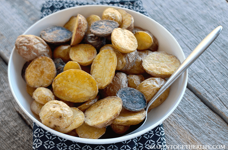 crispy Roasted Potatoes in a white bowl with a spoon