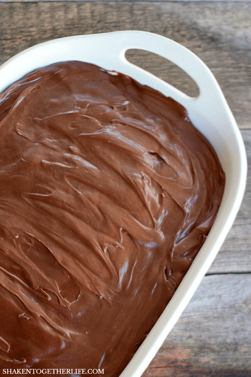 A perfectly frosted Boston Cream Pie Poke Cake in a white dish
