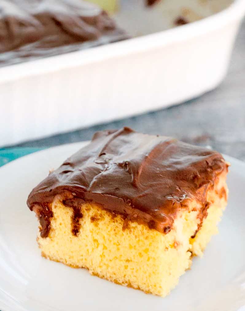 Boston Cream Pie Poke Cake on a white plate