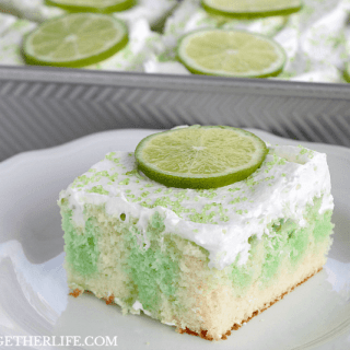Lime Poke Cake is a simple but stunning dessert! White cake, drenched in lime Jell-O and topped with fluffy whipped topping and lime slices, this easy lime cake is a stunner!