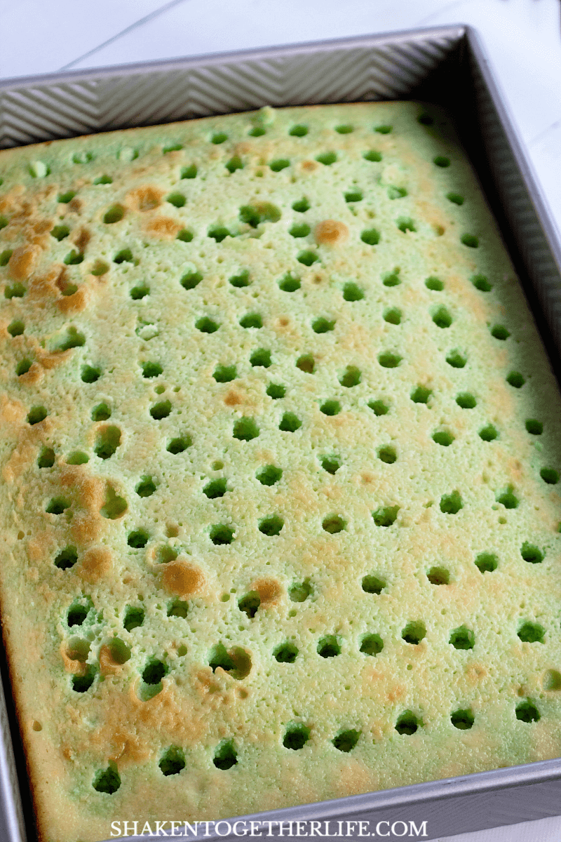 How to make a Lime Poke Cake - the first step is to poke holes all over a cooled white cake and drench it in lime Jell-o.