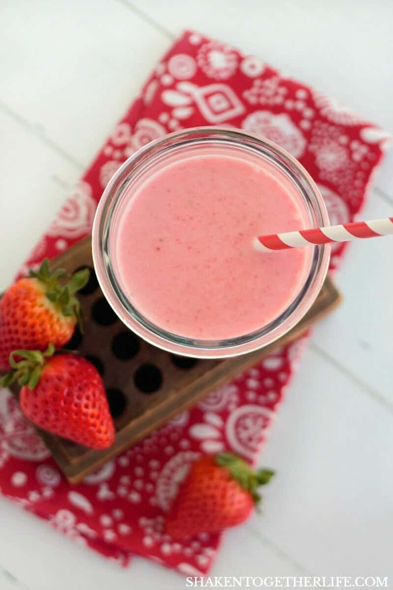 overhead view of frozen Strawberry Coladas with whole strawberries and red napkin