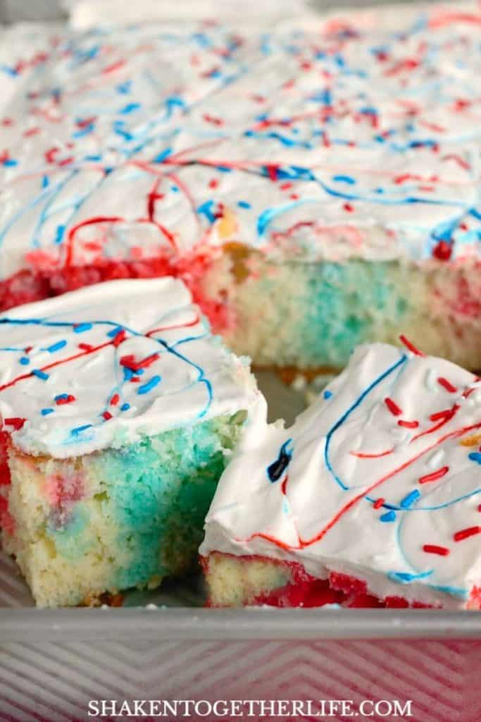 A table of Memorial Day desserts featuring a flag cake, red, white, and blue fruit parfaits, and star-shaped cookies.