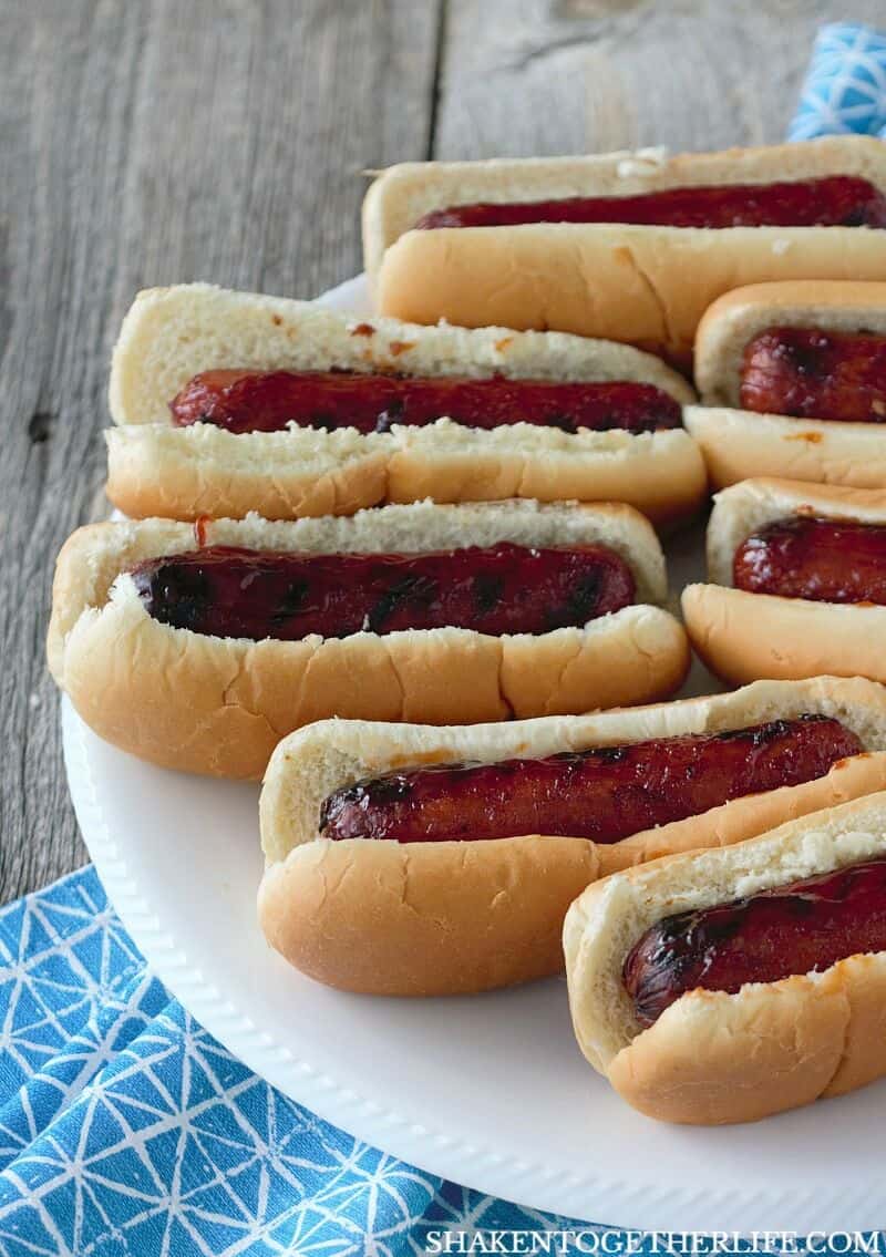 Grilled BBQ Glazed Smoked Sausage in buns on white plate