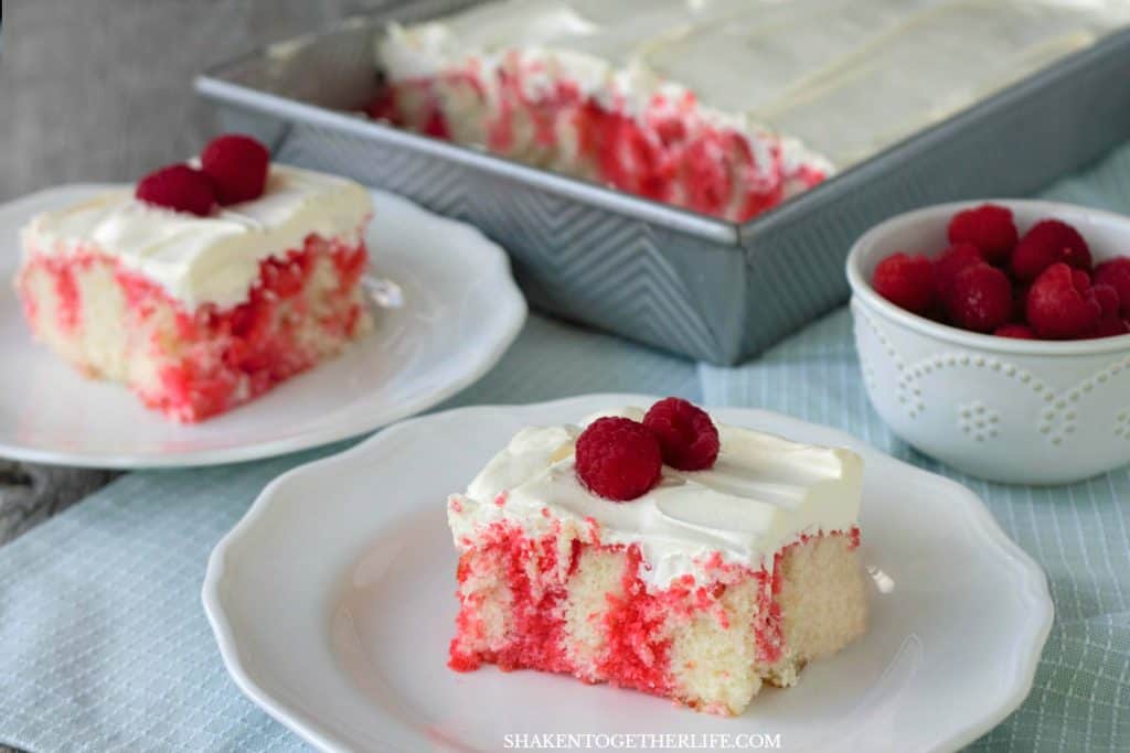 Raspberry Poke Cake pieces on white plates