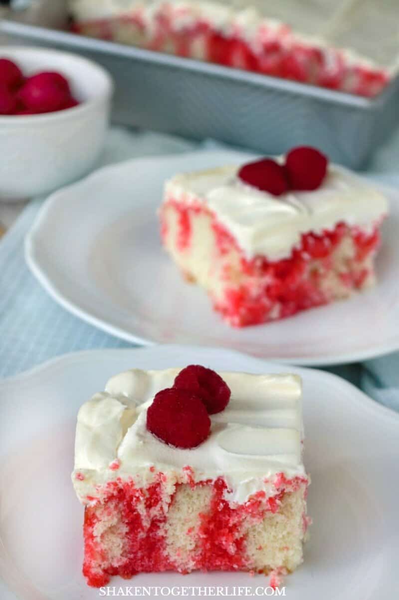 Raspberry Poke Cake is a soft white cake drenched in raspberry Jell-o, topped with whipped topping and then fresh raspberries. It is sweet and tangy, fruity and fabulous!