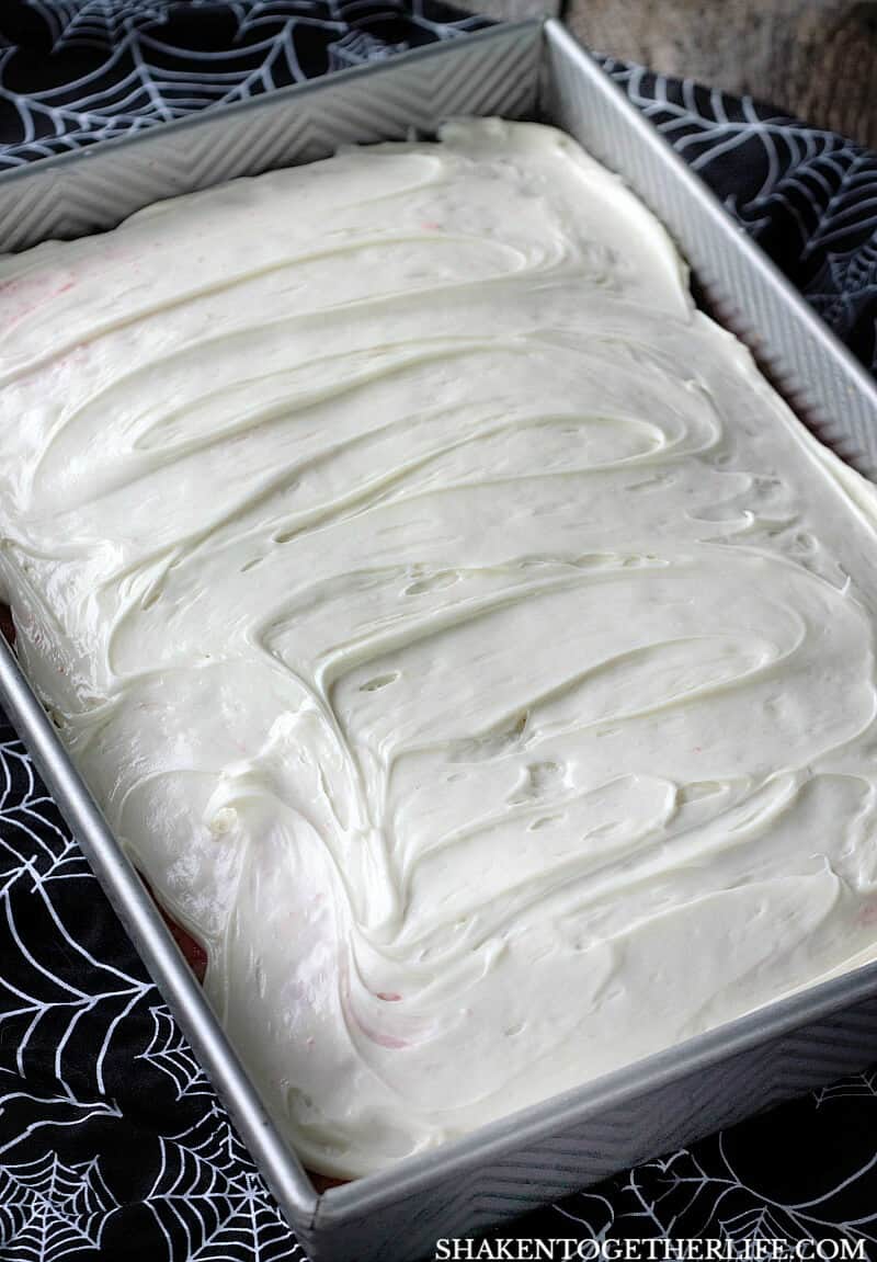 Cherry Vanilla Vampire Poke Cake is topped with a simple vanilla frosting