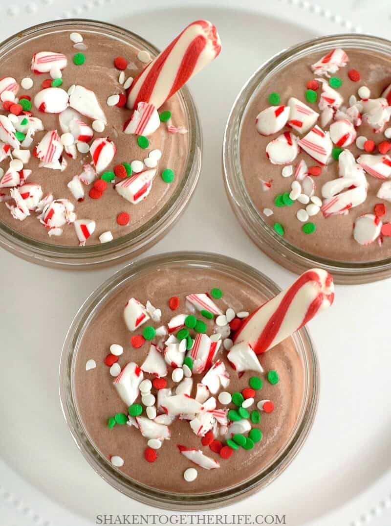 Peppermint Mocha Pudding Mousse is garnished with chopped candy canes, holiday sprinkles and a peppermint stick! This is a seriously easy and delicious no bake holiday dessert!