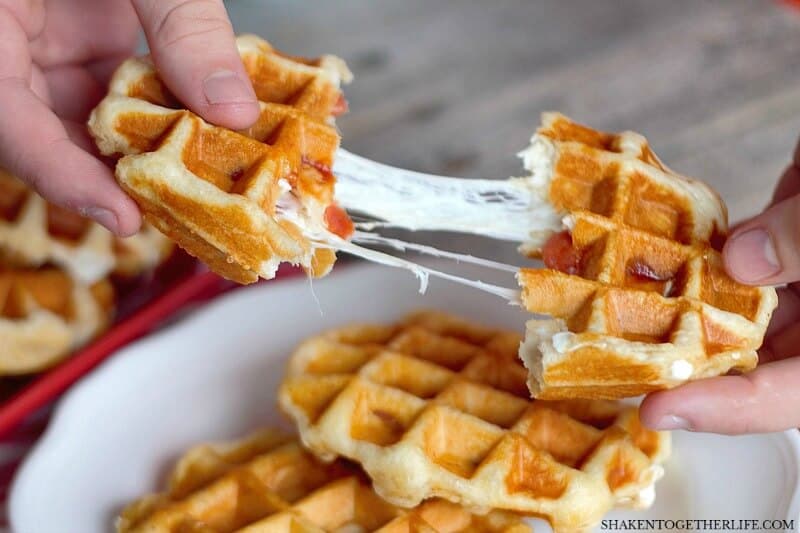 Pizza Stuffed Waffles - just look at that gooey melty cheese pull! This easy dinner recipe has just 4 ingredients and starts with refrigerator biscuits.