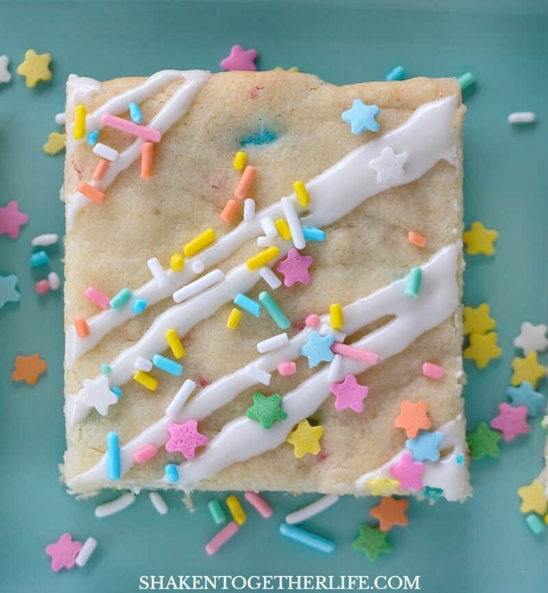 Funfetti Cookie Bars! These easy dessert starts with a funfetti cake mix and ends up drizzled with frosting and tons of colorful sprinkles!