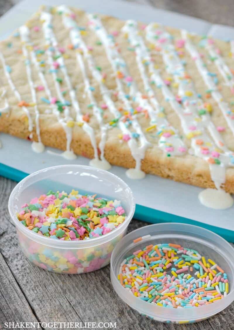 Funfetti Cookies Bars from a Cake Mix! This easy dessert gets a drizzle of vanilla frosting and loaded with colorful sprinkles!