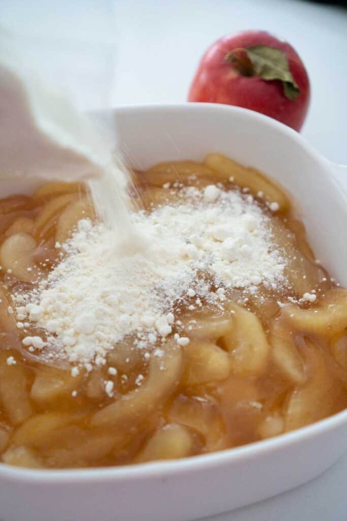 pouring cake mix over apple pie filling