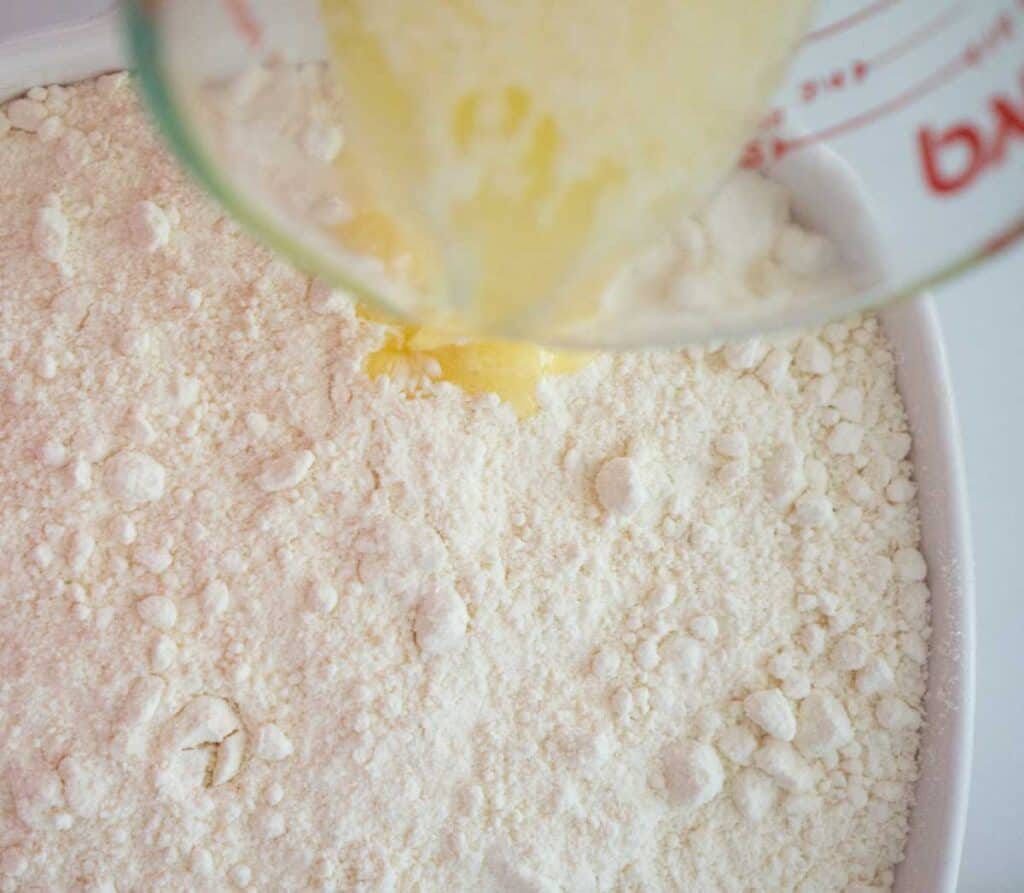 pouring melted butter over cake mix