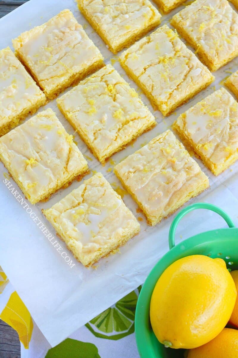 Lemon Glazed Lemon Bars on parchment paper