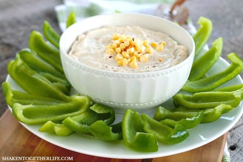 Creamy Chipotle Ranch Dip in a bowl surrounded by sliced green bell peppers