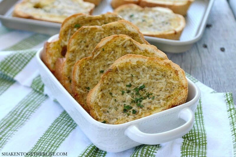 Homemade Pesto Parmesan Garlic Bread in white serving platter