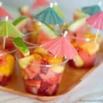 Easy Tropical Fruit Salad served with a paper party umbrella is sweet, healthy & refreshing! It makes the perfect dessert for a Tropical Summer Craft Party!