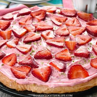 With a strawberry cookie base, strawberry frosting and fresh sliced strawberries, this Strawberry Dessert Pizza is a crowd pleaser! It starts with a cake mix, so this simple dessert is perfect for entertaining!